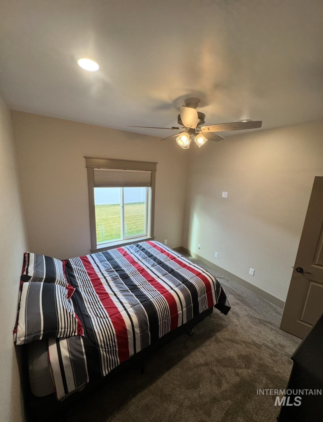 Carpeted bedroom featuring ceiling fan and recessed lighting