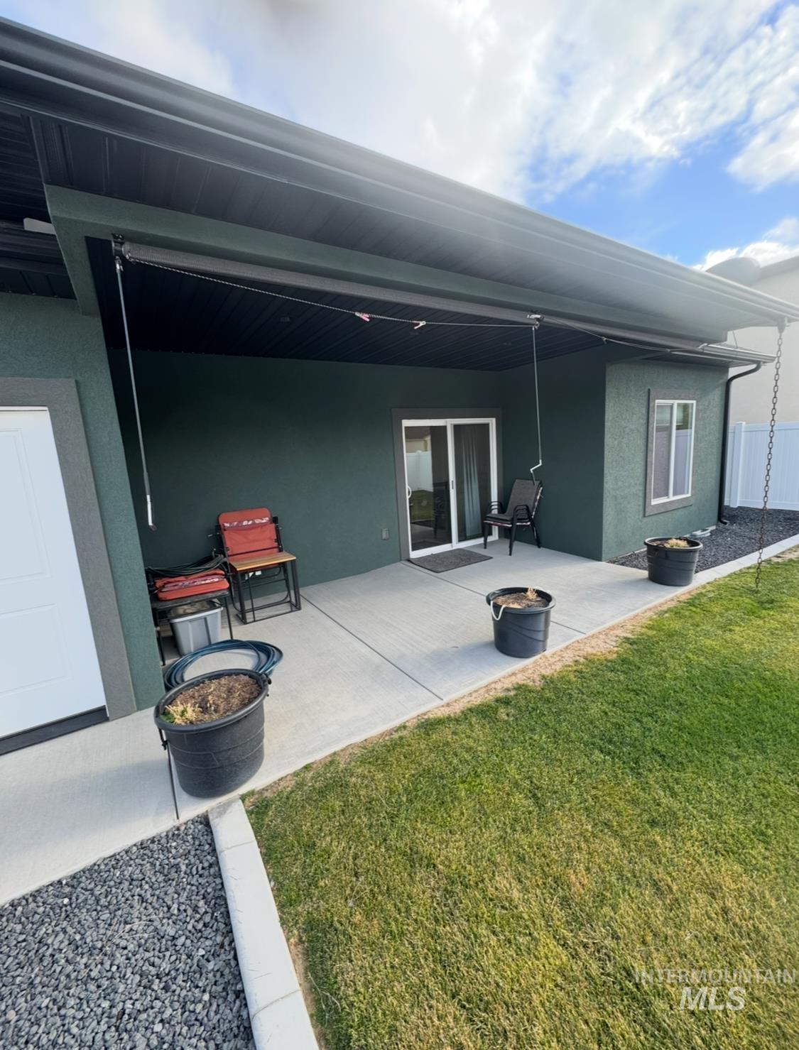 Back of house featuring stucco siding, a patio area, a lawn, and an outdoor fire pit