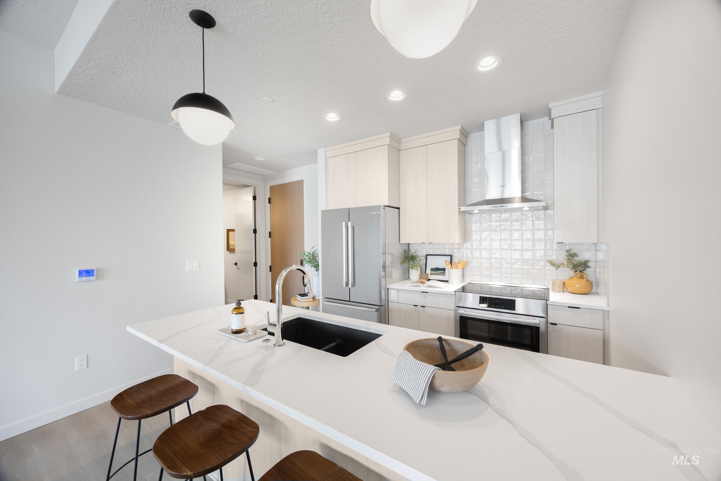 Kitchen with a kitchen breakfast bar, wall chimney exhaust hood, backsplash, recessed lighting, and high end fridge