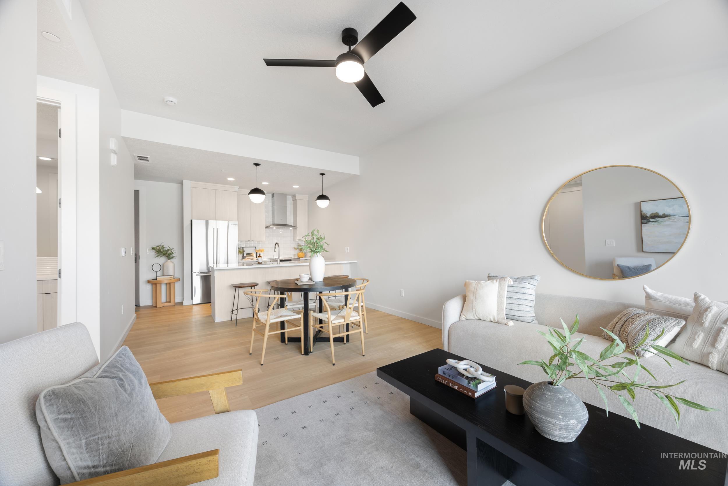 Living area with light wood-style flooring, ceiling fan, and recessed lighting