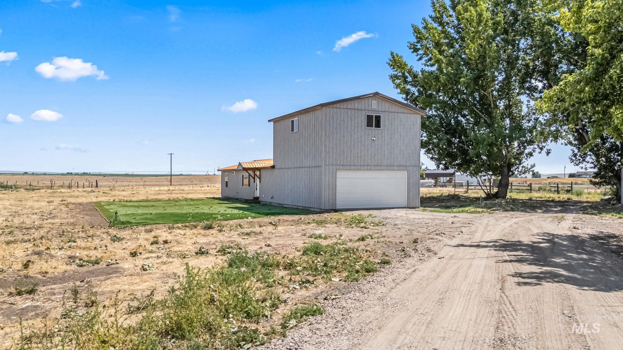 View of side of property featuring a view of rural / pastoral area and dirt driveway