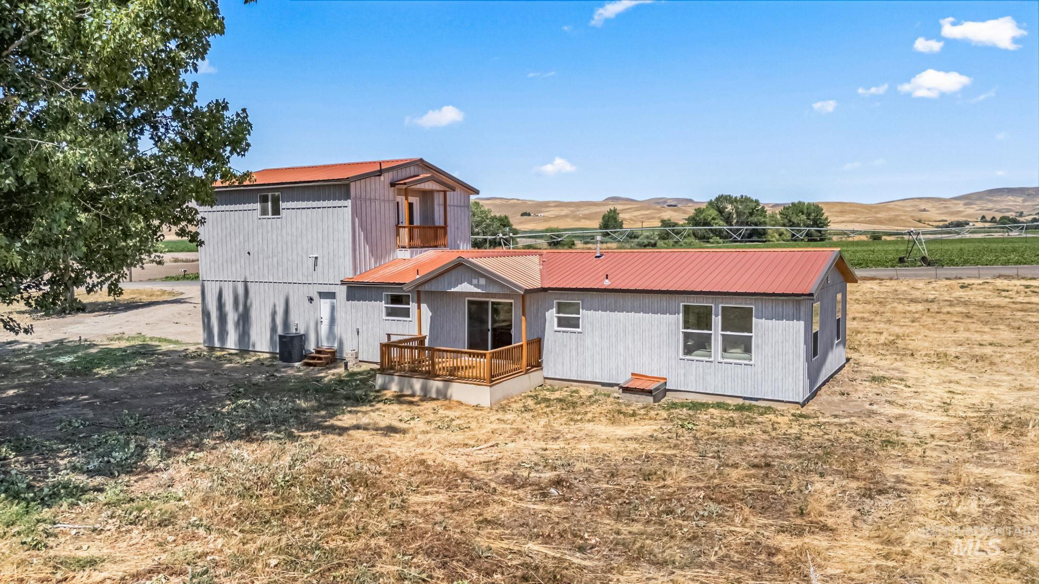 Rear view of house with a metal roof and a deck with mountain view