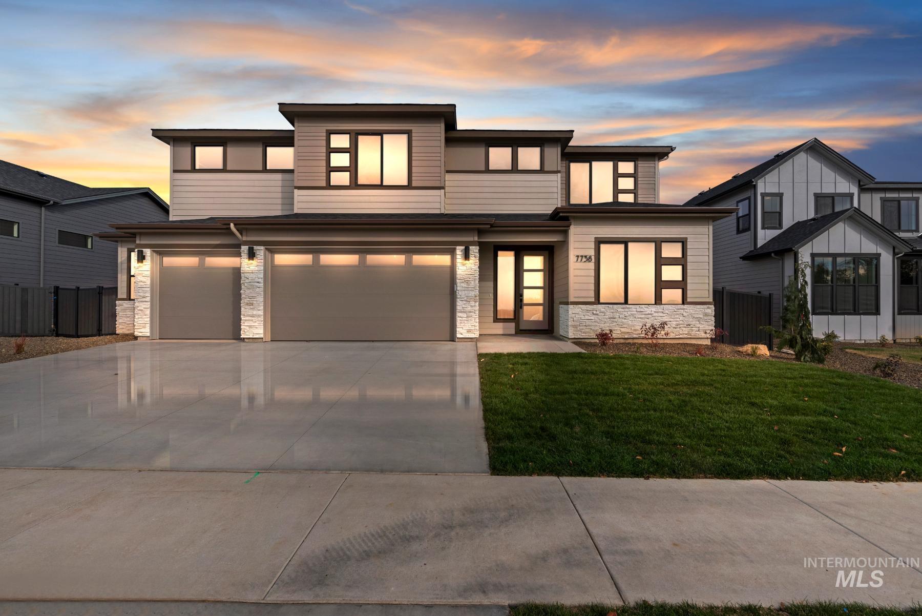 View of front facade with stone siding, concrete driveway, and a garage