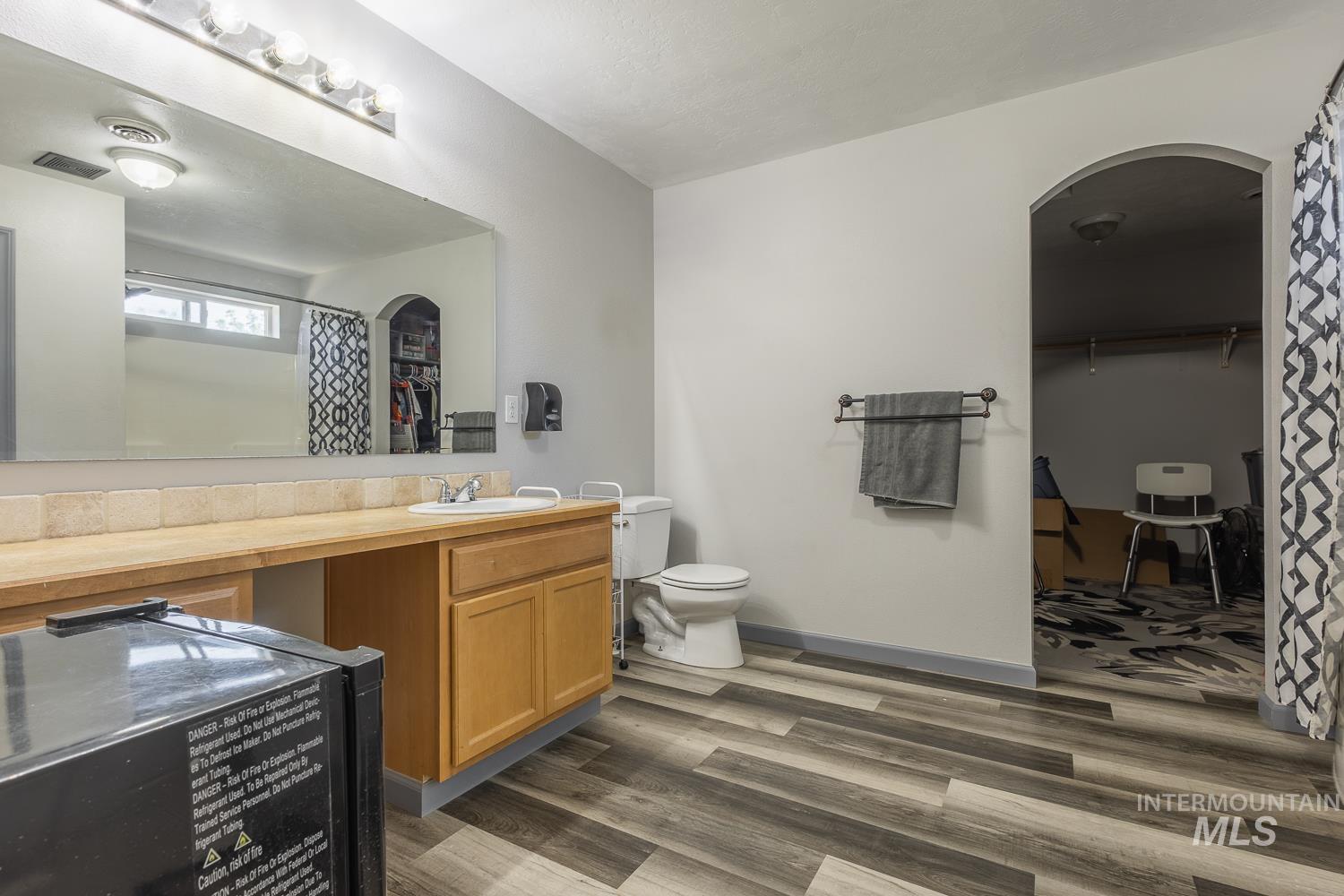 Bathroom featuring a walk in closet, dark wood-type flooring, vanity, and a shower with shower curtain