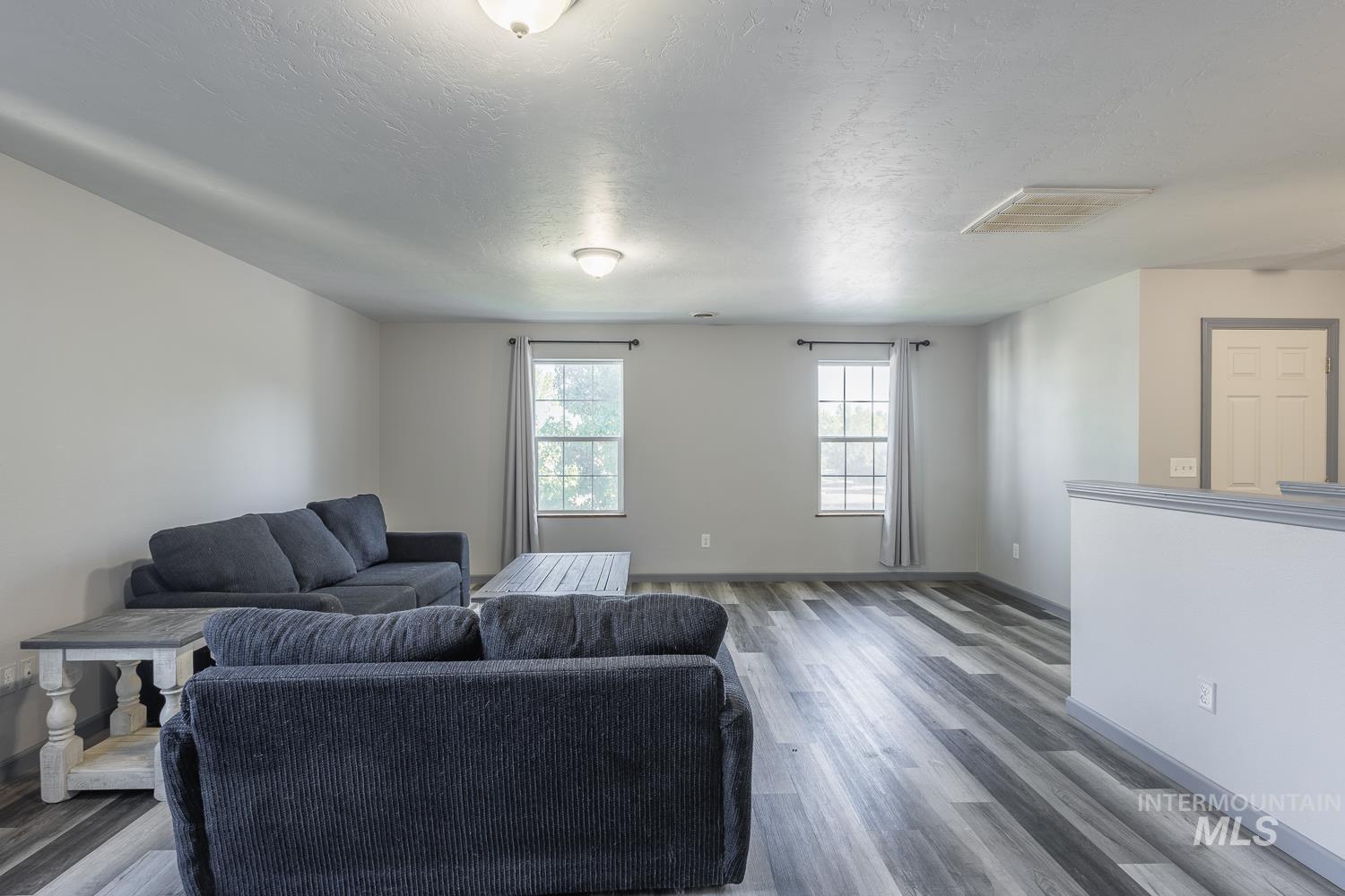 Living area with a textured ceiling and wood finished floors