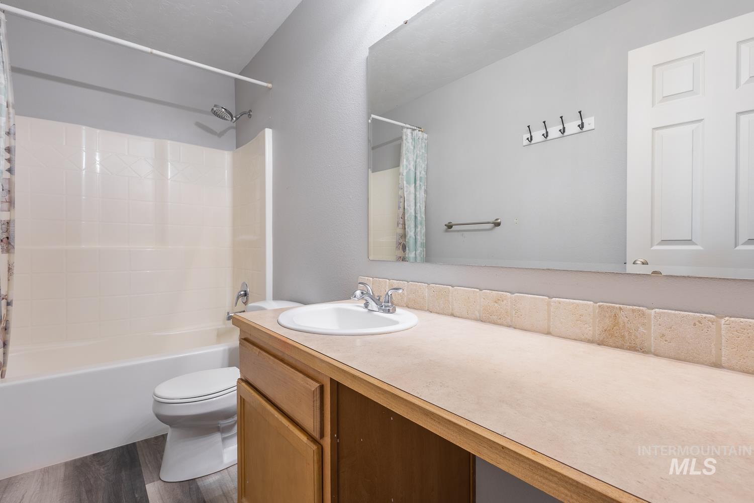 Bathroom featuring shower / bath combo, vanity, and dark wood finished floors