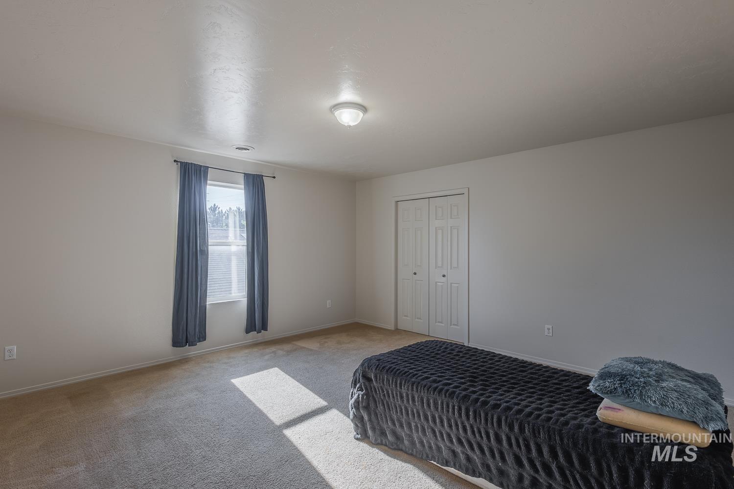 Bedroom featuring carpet flooring and a closet