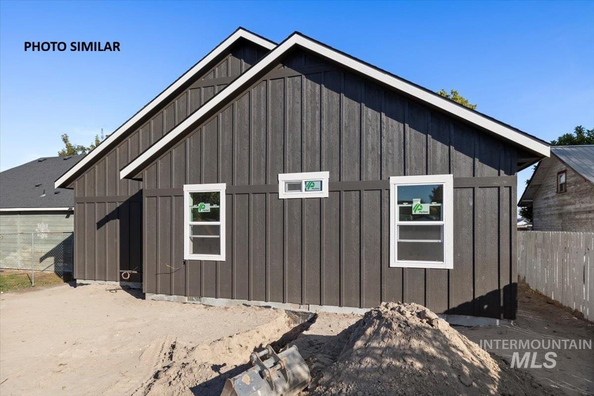 Back of house featuring board and batten siding and an outbuilding