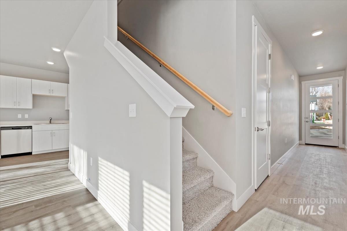 Stairs featuring recessed lighting and wood finished floors