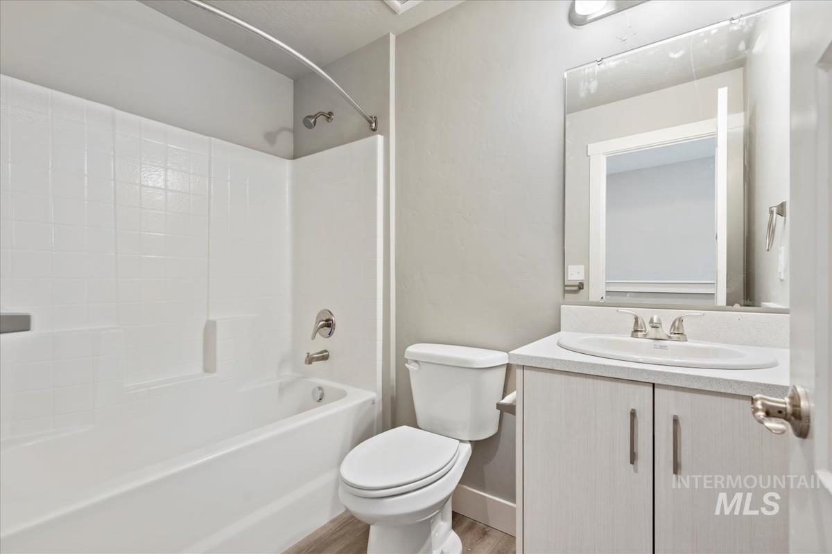 Bathroom featuring bathtub / shower combination, vanity, and light wood finished floors