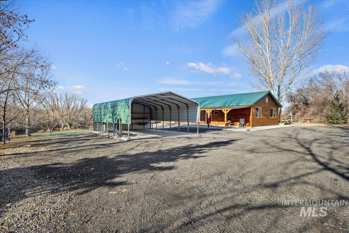 View of outbuilding with a carport and driveway