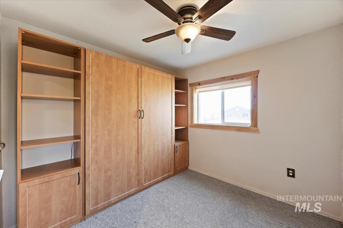 Unfurnished bedroom with a ceiling fan and light carpet