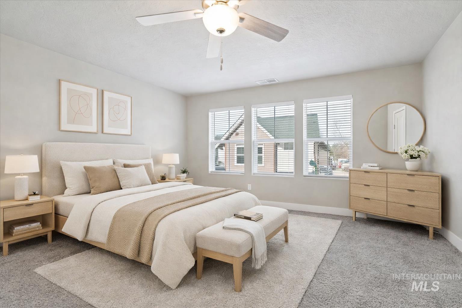 Bedroom with light colored carpet, a ceiling fan, and a textured ceiling