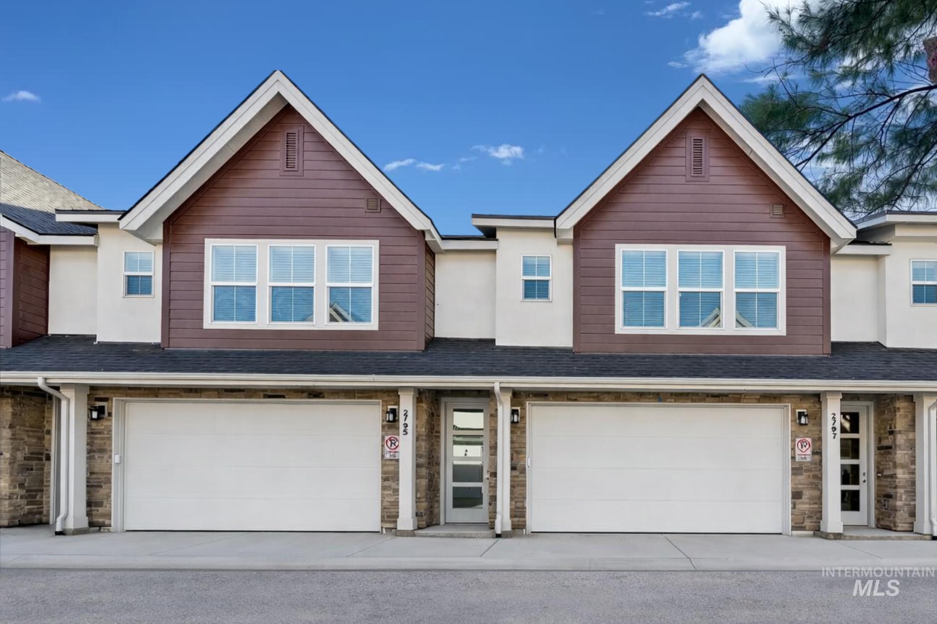 Craftsman-style home featuring roof with shingles, stone siding, and an attached garage