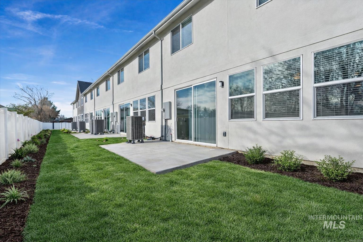 Back of house with stucco siding, a patio area, and a fenced backyard
