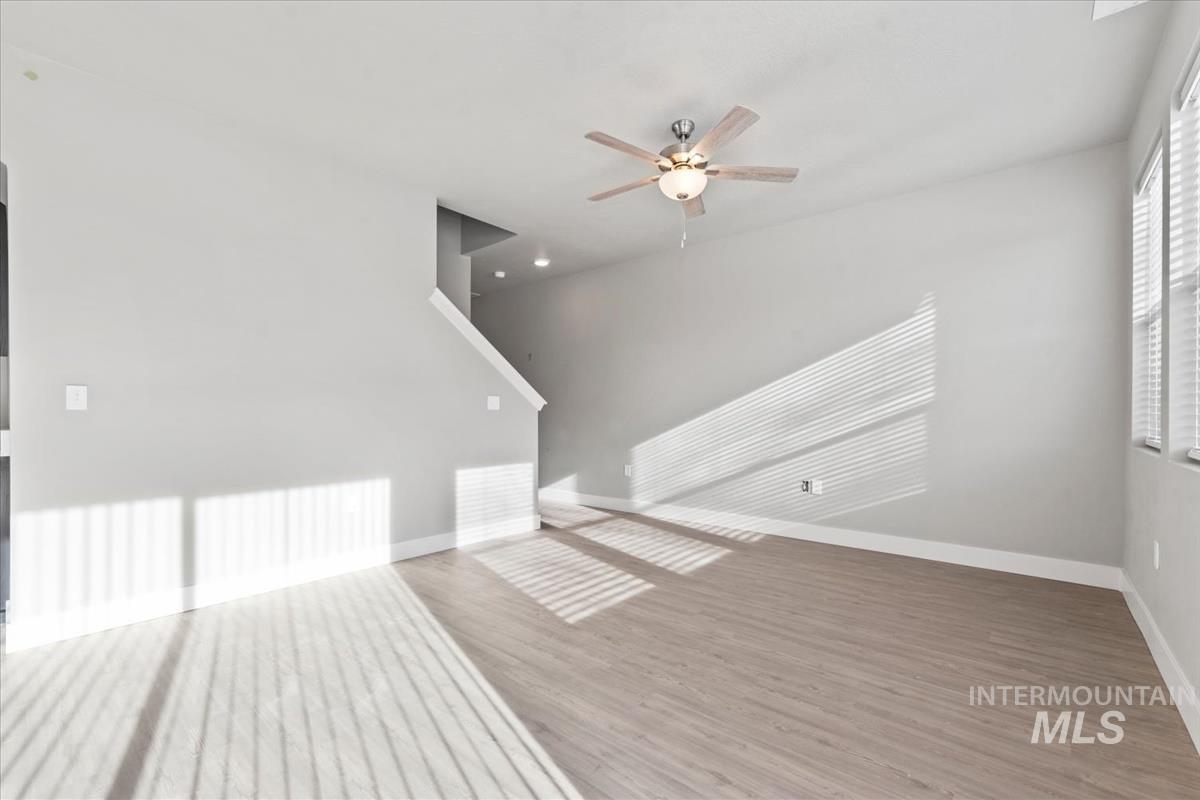 Unfurnished living room with a ceiling fan and light wood-style flooring