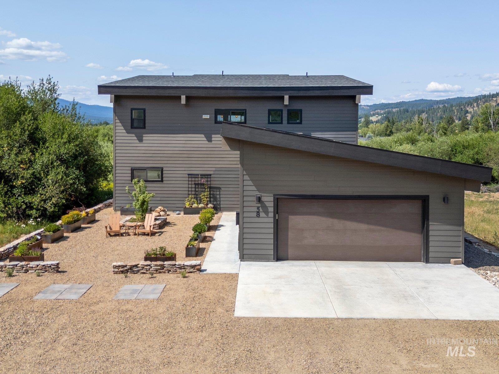 View of front of home with concrete driveway, 2 car garage with EV charging, and a mountain view