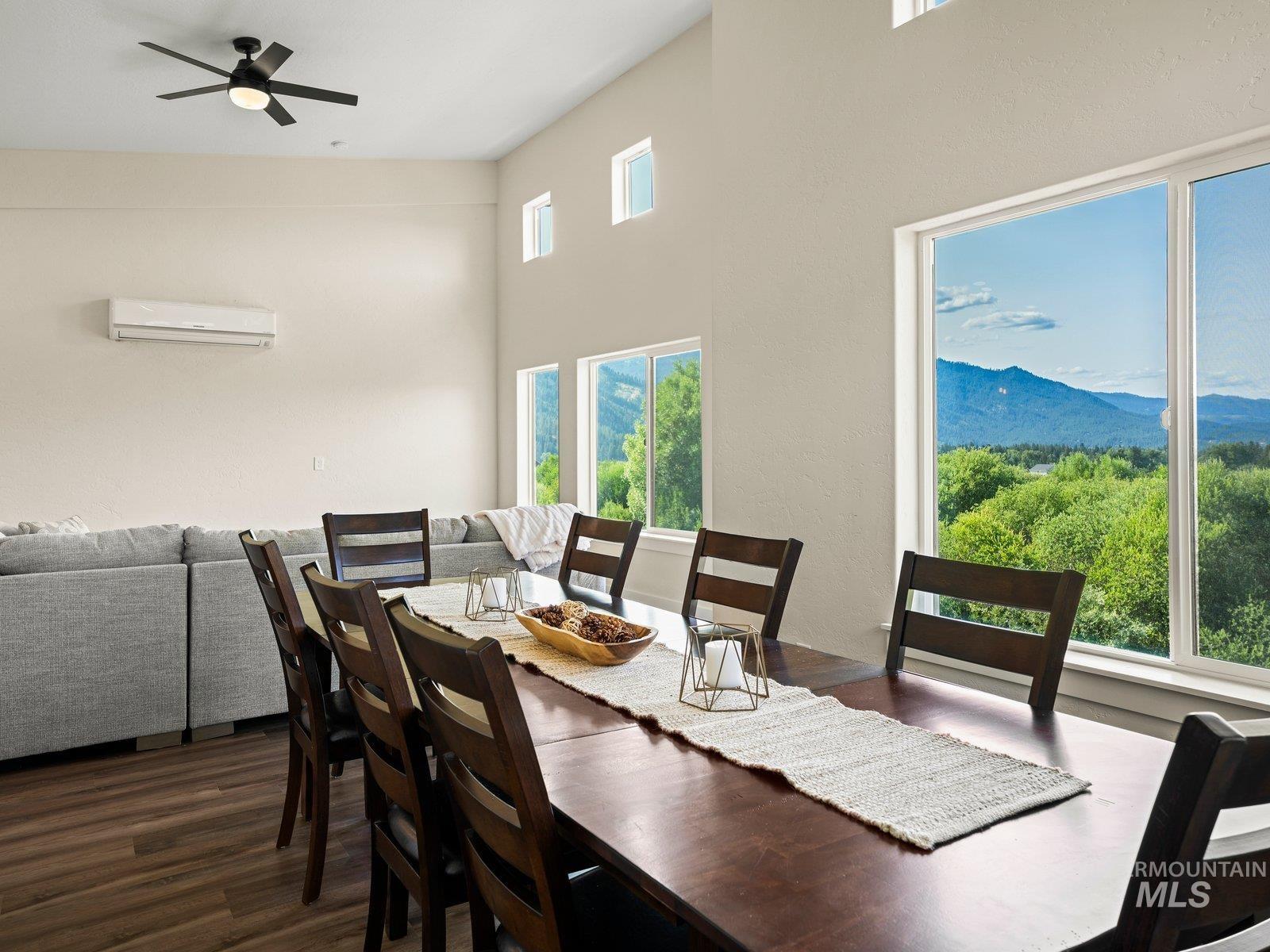 Dining room with a high ceiling, laminate plank floors, a ceiling fan,  mountain and valley views