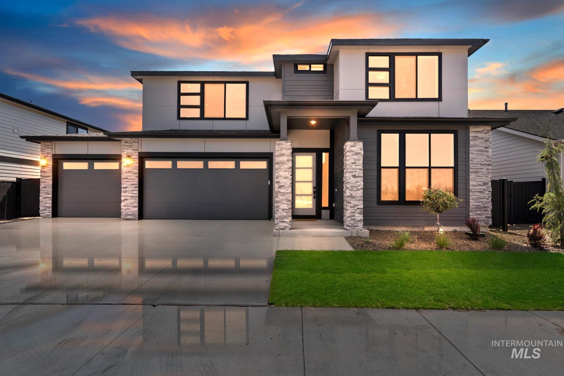 Modern home featuring stone siding, driveway, stucco siding, and a garage