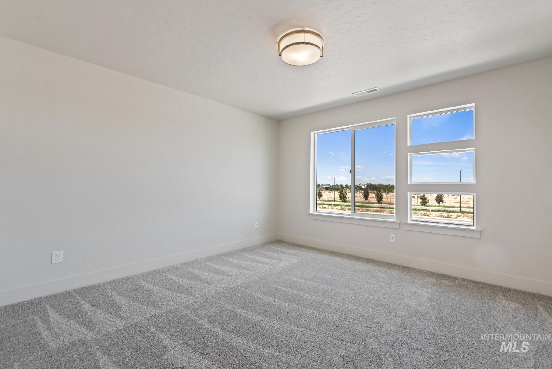 Spare room featuring carpet flooring and baseboards