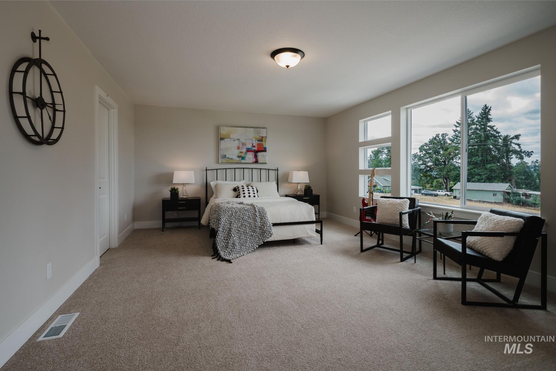Bedroom with light colored carpet and baseboards