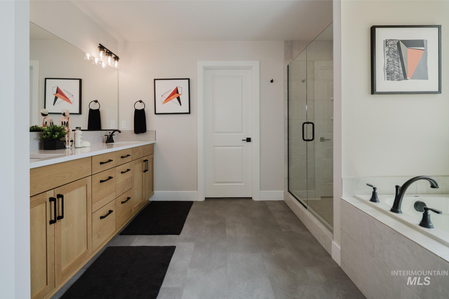 Full bath featuring double vanity, a bath, a shower stall, and light floors