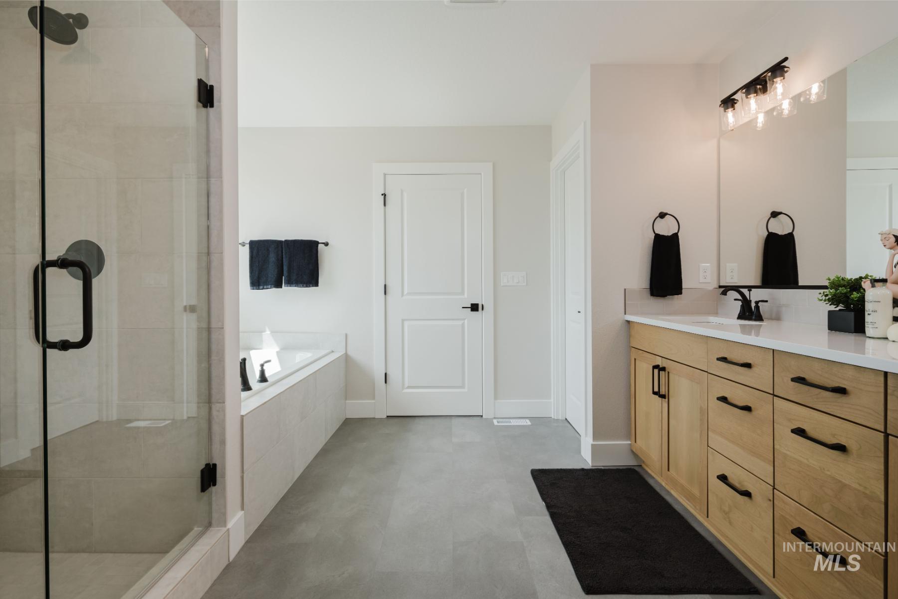 Full bathroom featuring a bath, vanity, and a stall shower