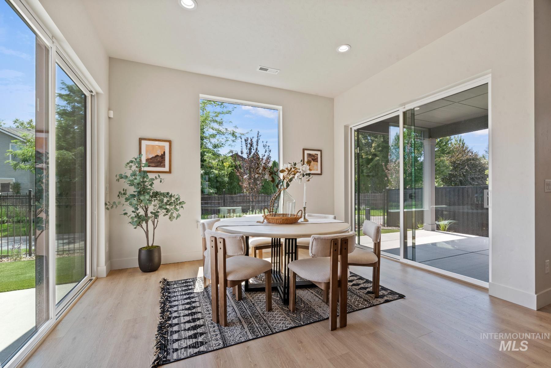 Dining area featuring light wood-style floors, plenty of natural light, and recessed lighting