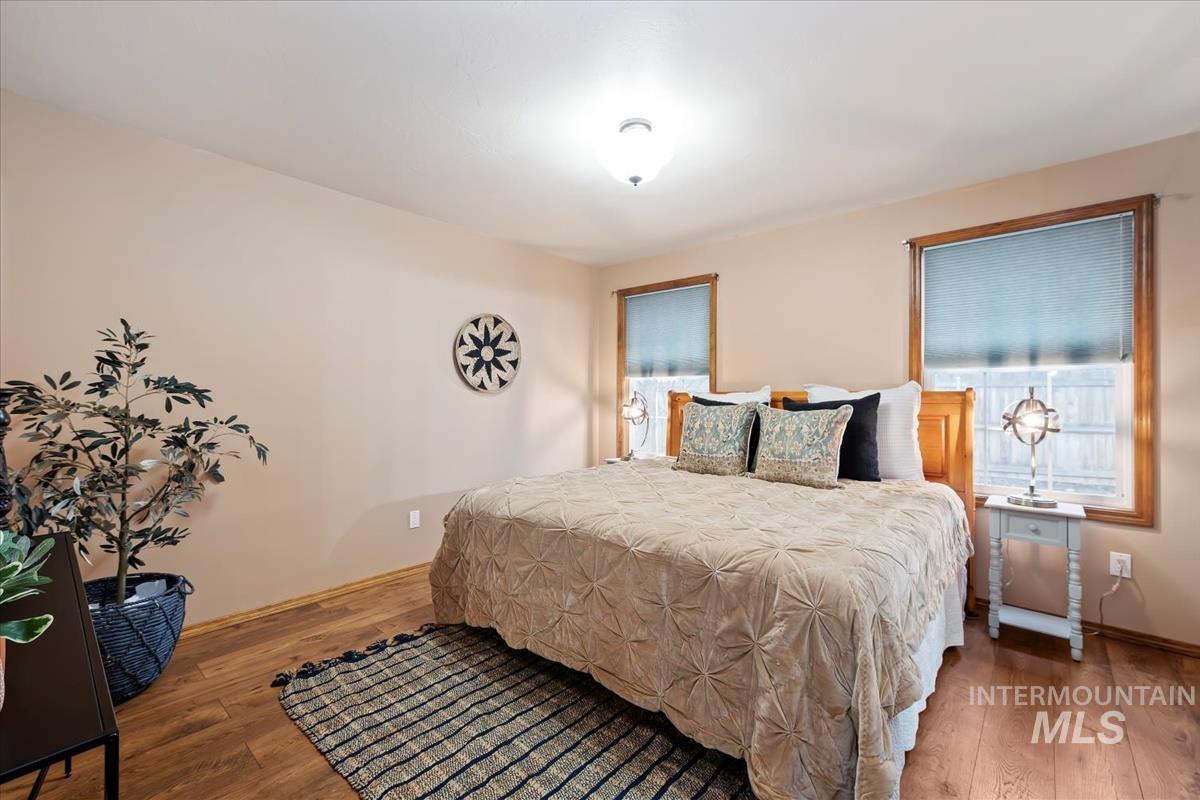 Bedroom with hardwood / wood-style floors and multiple windows