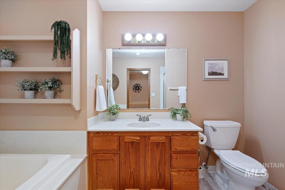 Bathroom with vanity, a bath, and a stall shower
