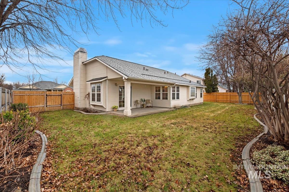 Back of house with a patio, a fenced backyard, a chimney, and roof with shingles