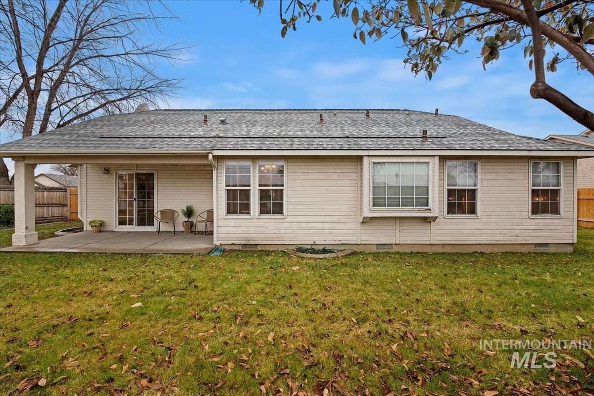 Back of house with a shingled roof, crawl space, and a patio area
