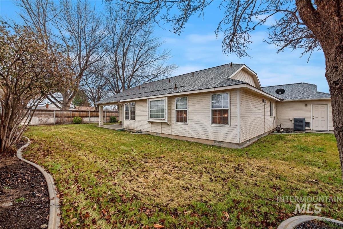 Rear view of property with a fenced backyard, a patio area, roof with shingles, and crawl space