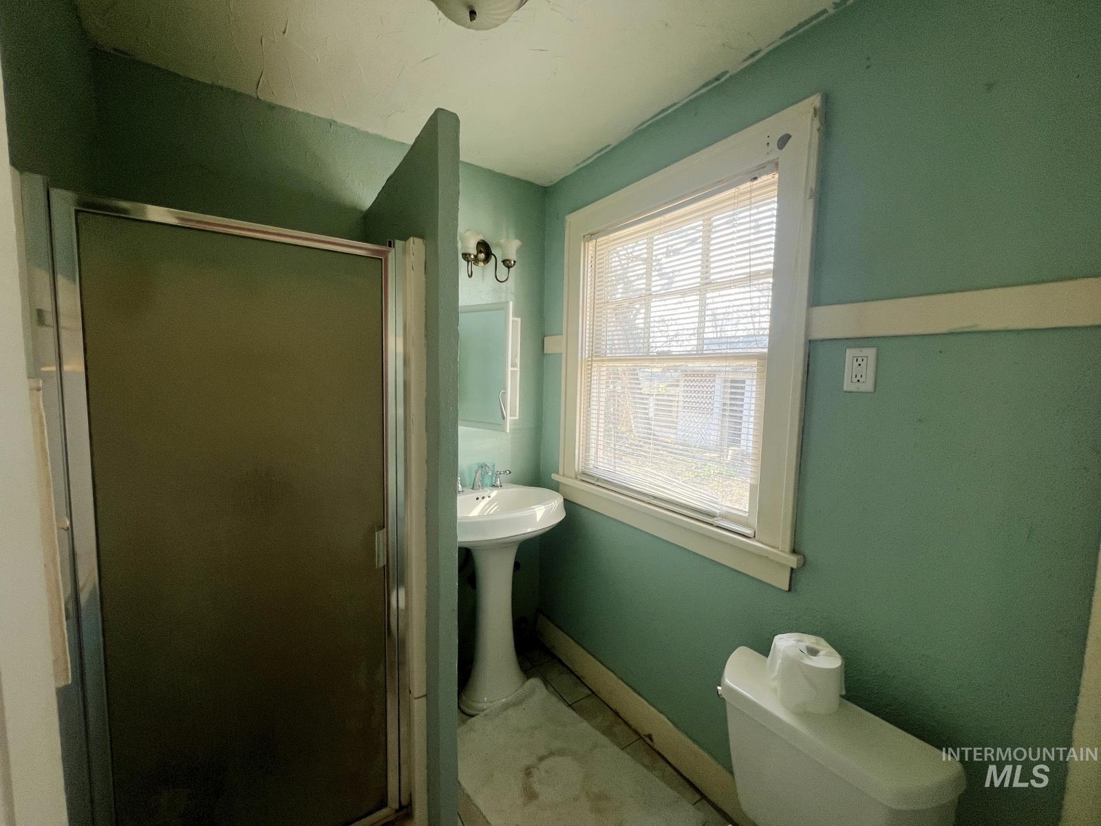 Bathroom with a shower stall and toilet