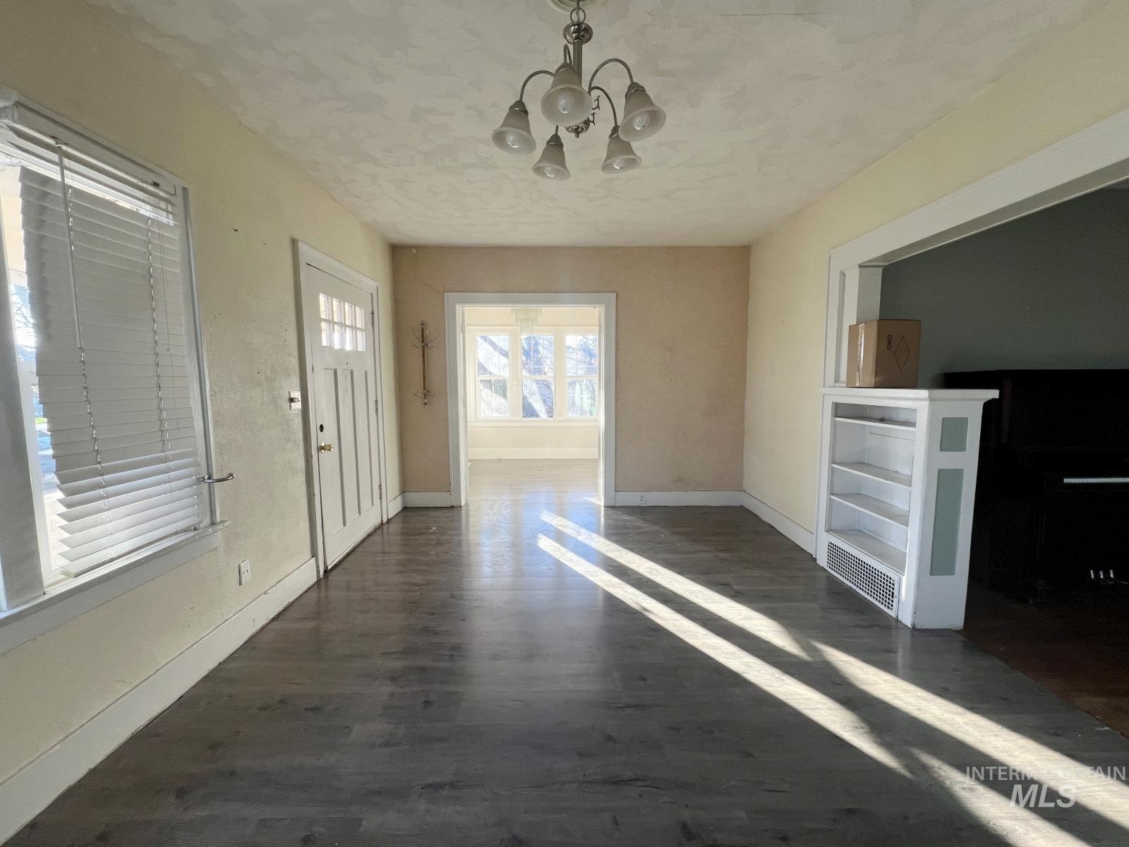 Entryway with a chandelier, dark wood-style flooring, and a textured ceiling
