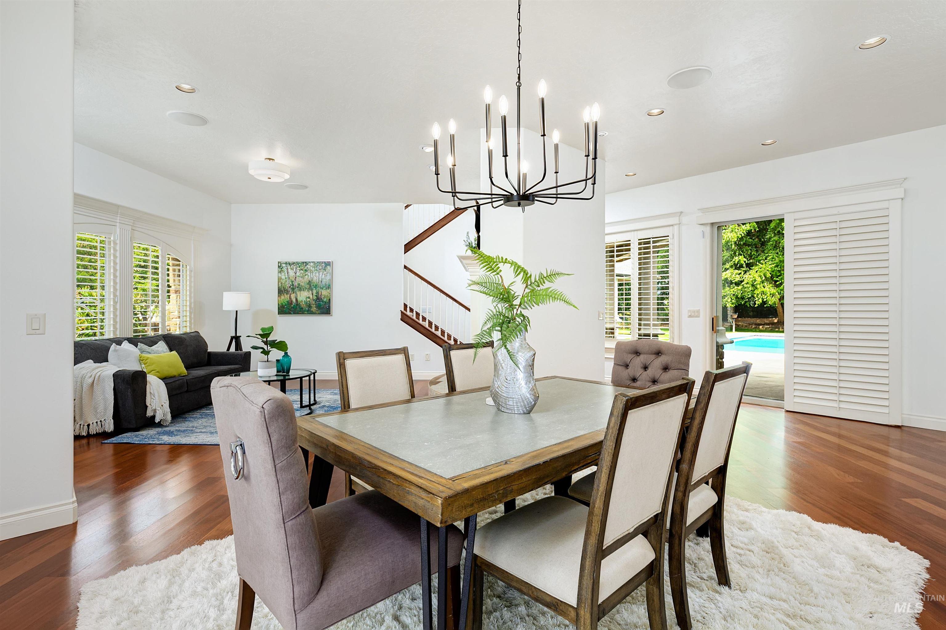 Dining room with wood finished floors, stairway, recessed lighting, and a chandelier