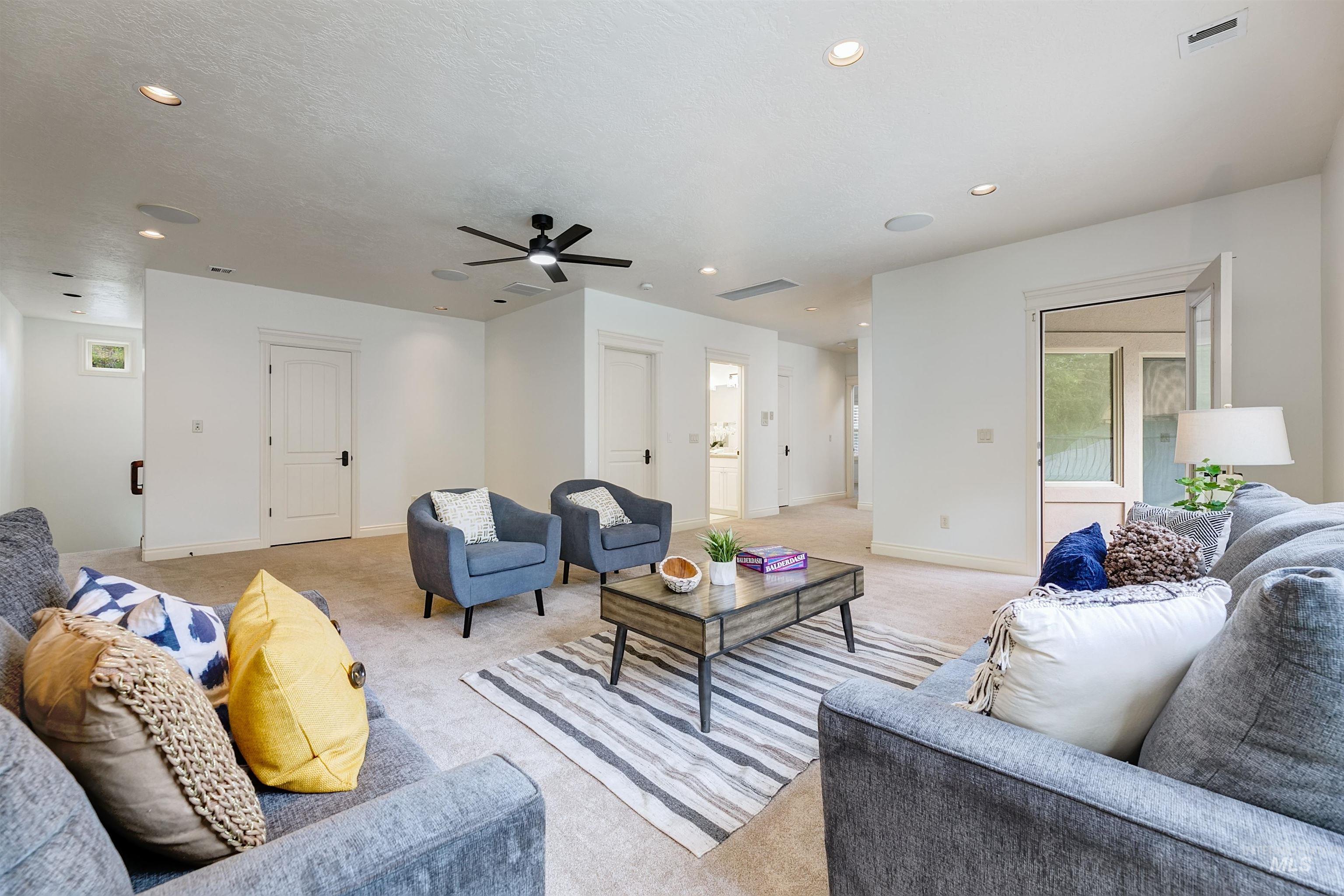 Living room featuring carpet floors, recessed lighting, ceiling fan, and a textured ceiling