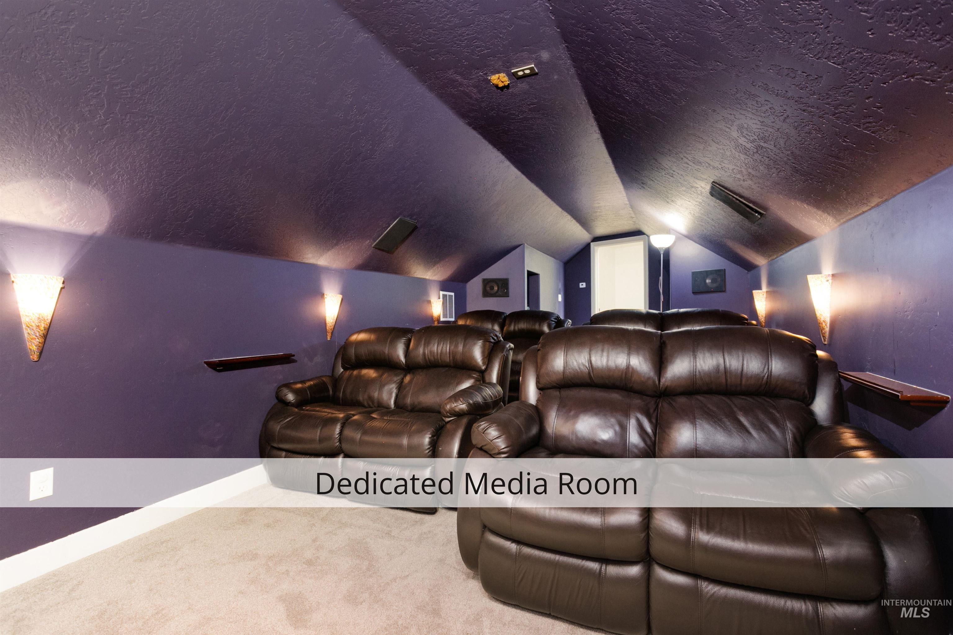 Cinema room featuring a textured ceiling, carpet floors, and vaulted ceiling