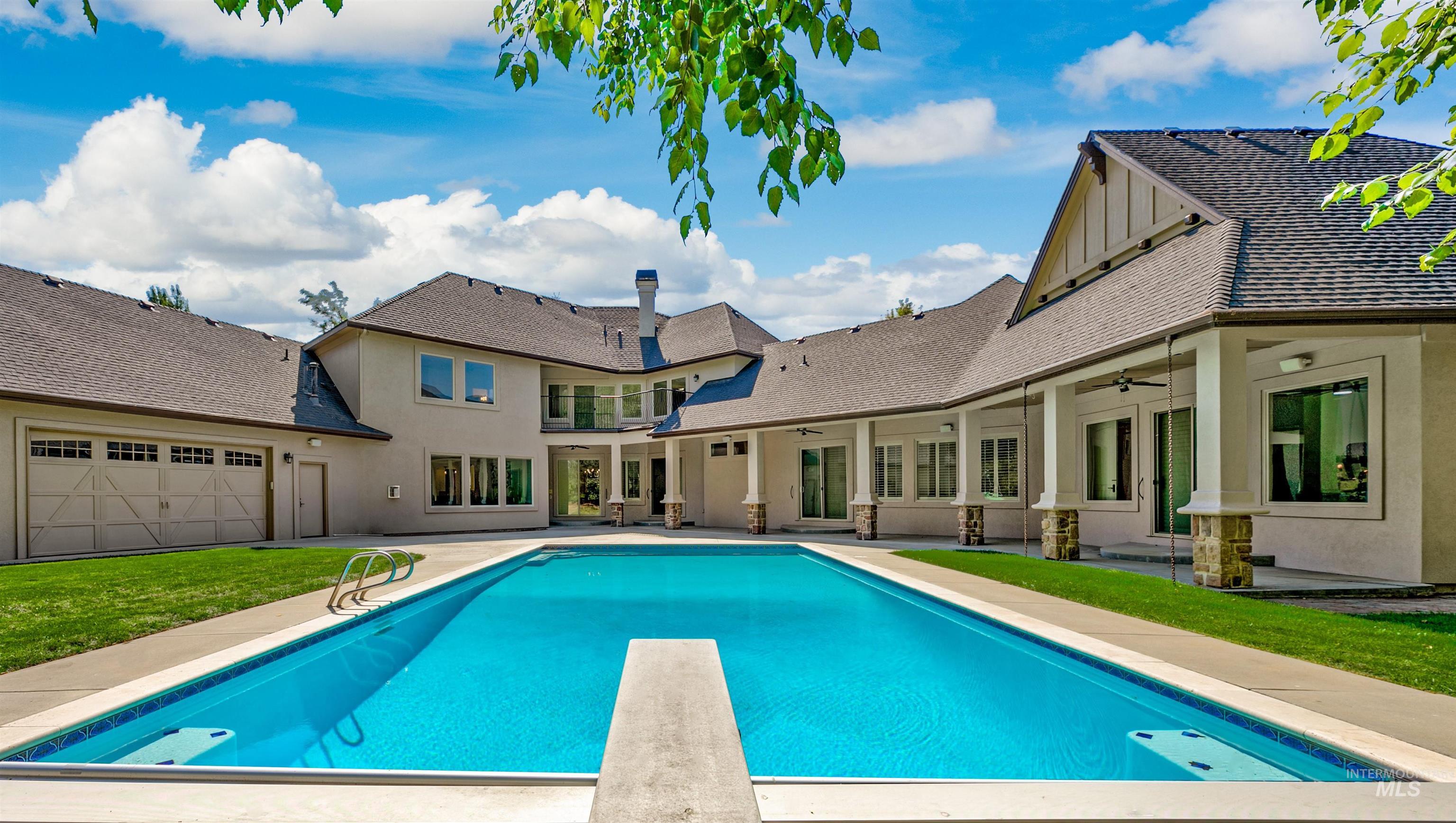 View of swimming pool with a patio, a diving board, ceiling fan, and a yard