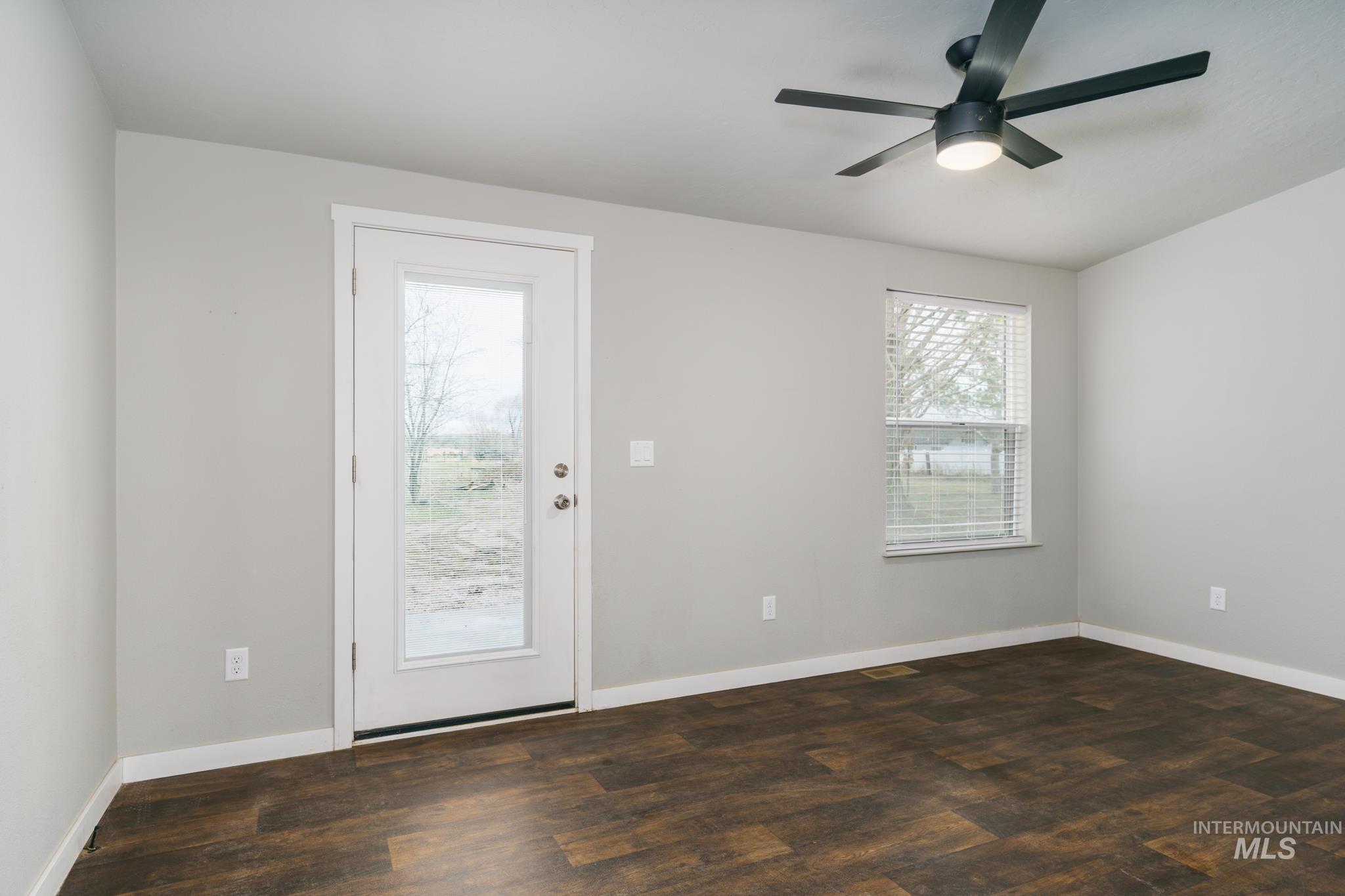 Doorway with wood finished floors and ceiling fan