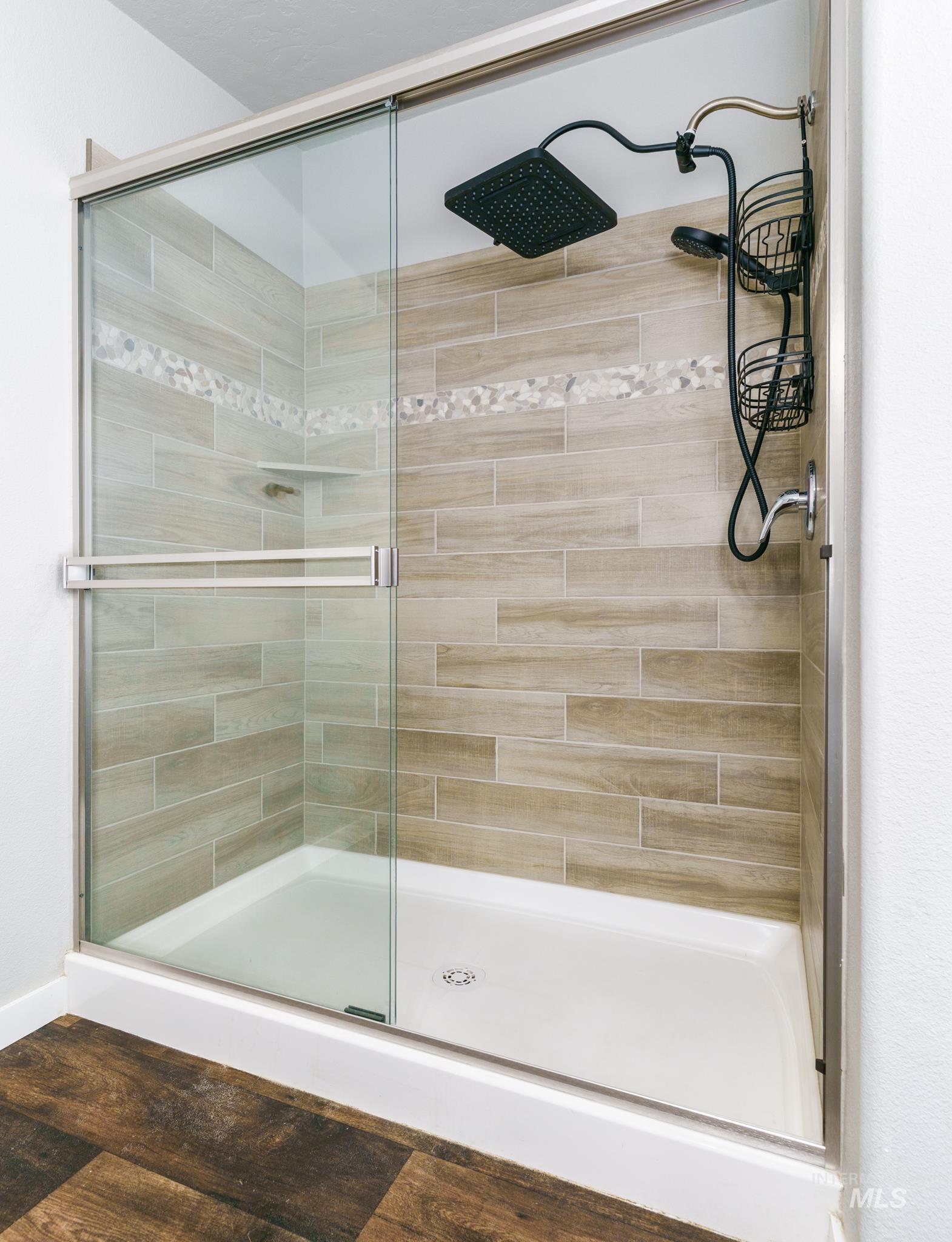 Full bathroom with a stall shower and wood finished floors