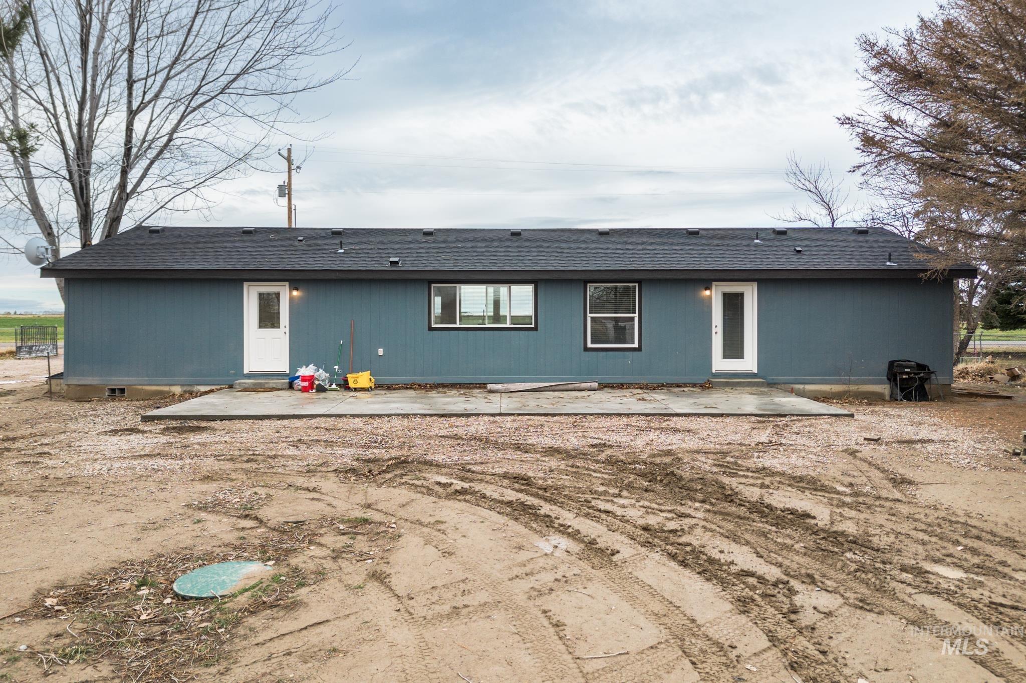 Rear view of property with a patio area and roof with shingles