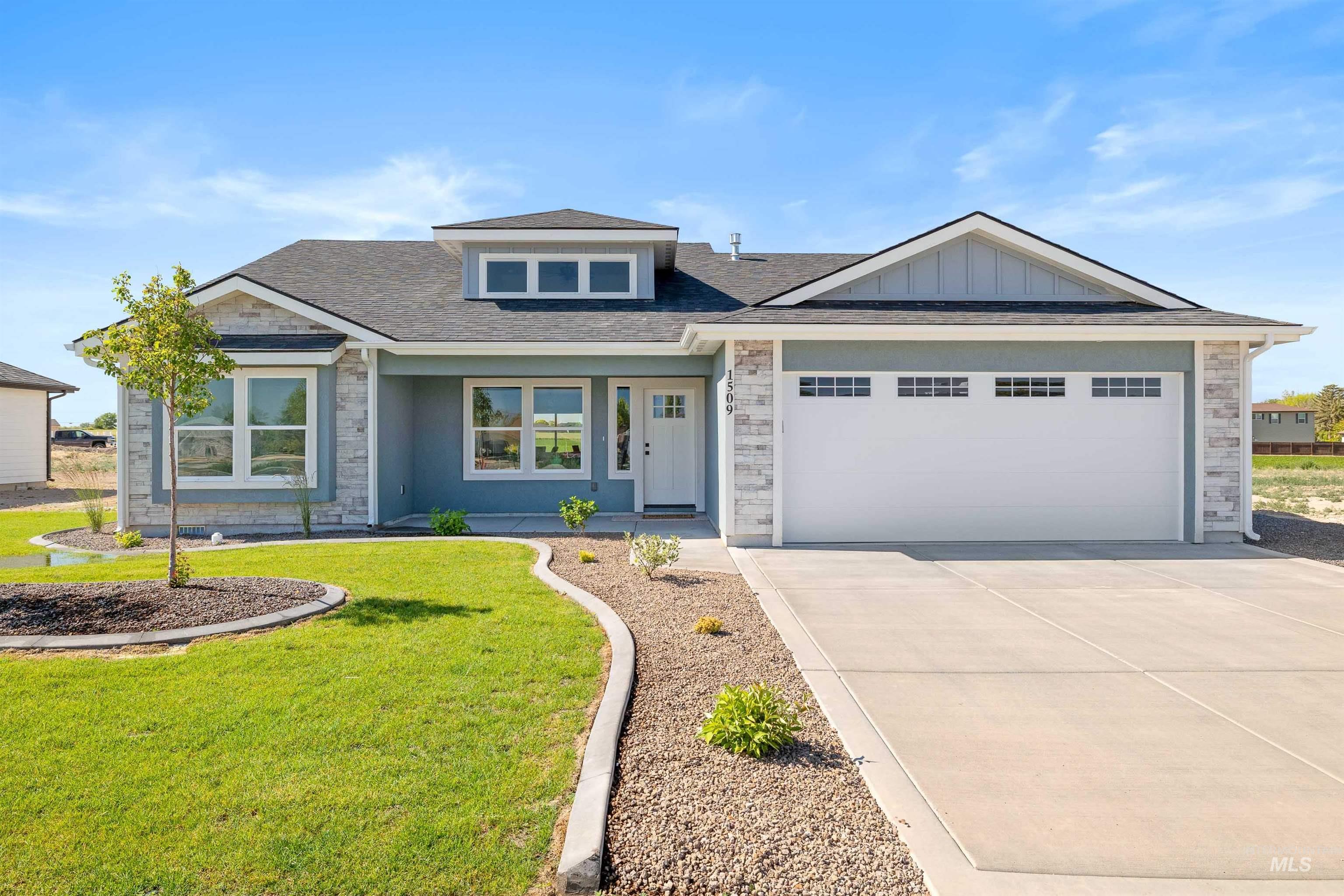 View of front of property with stone siding, driveway, a front yard, and an attached garage