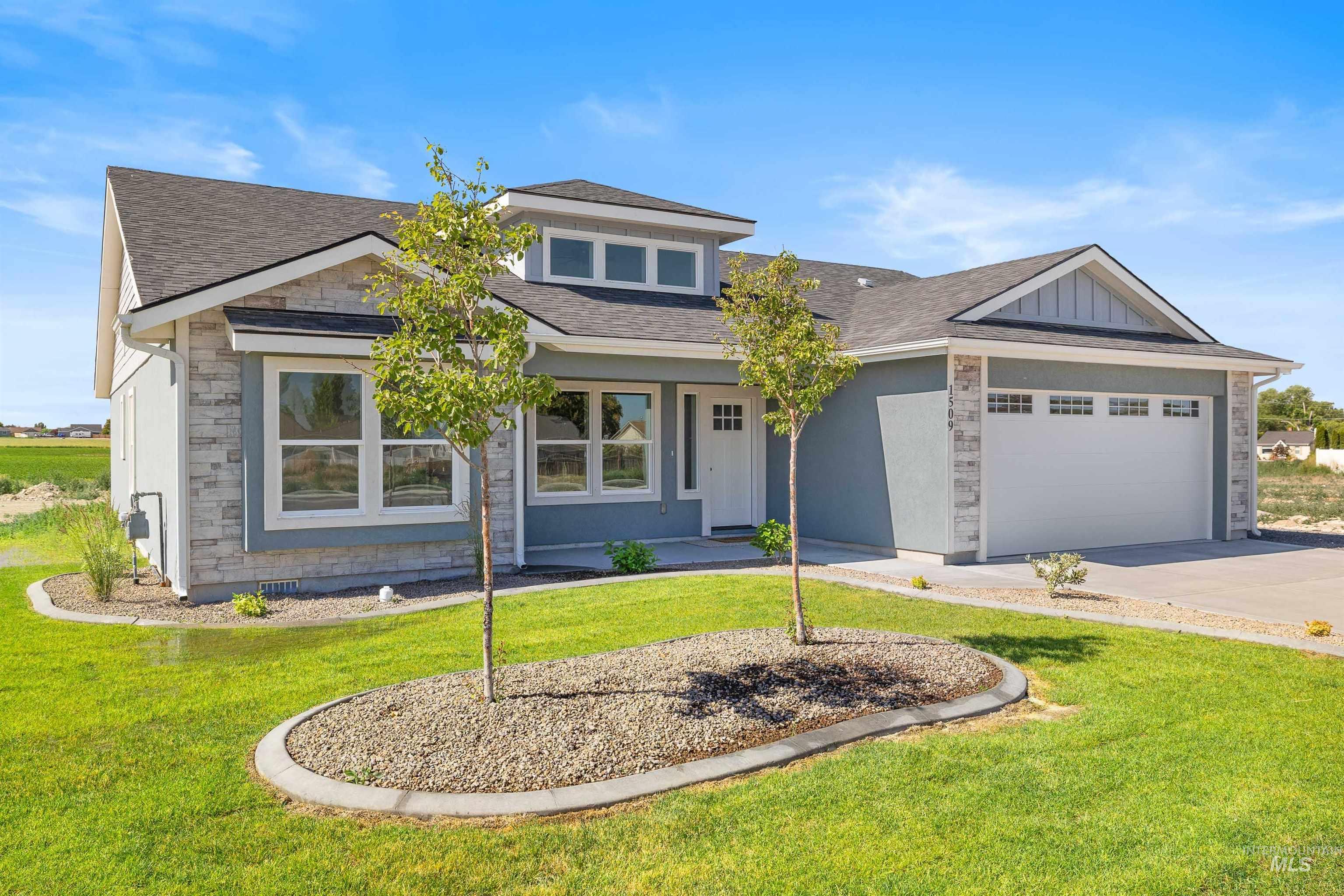 View of front of home featuring a garage, stone siding, driveway, a front yard, and roof with shingles