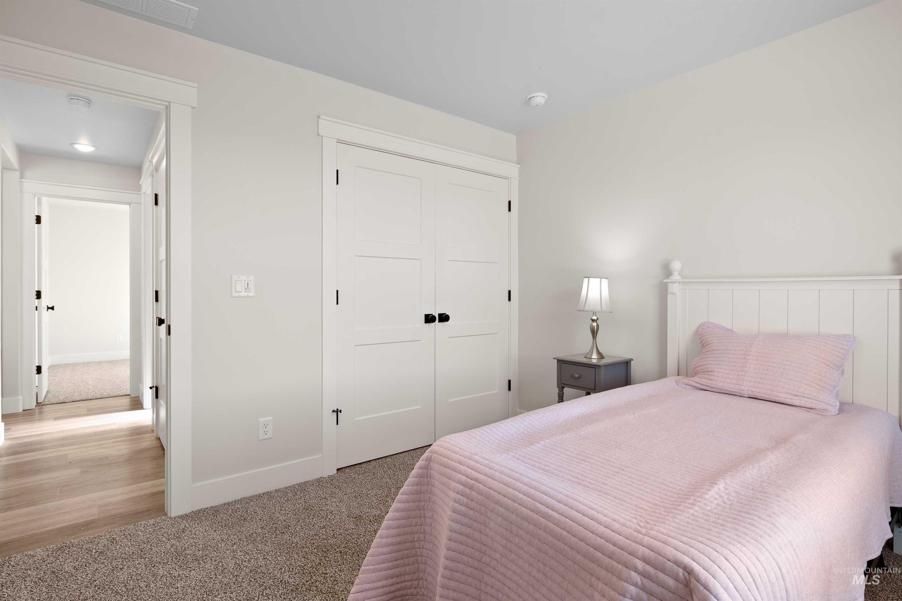 Carpeted bedroom with a closet and baseboards