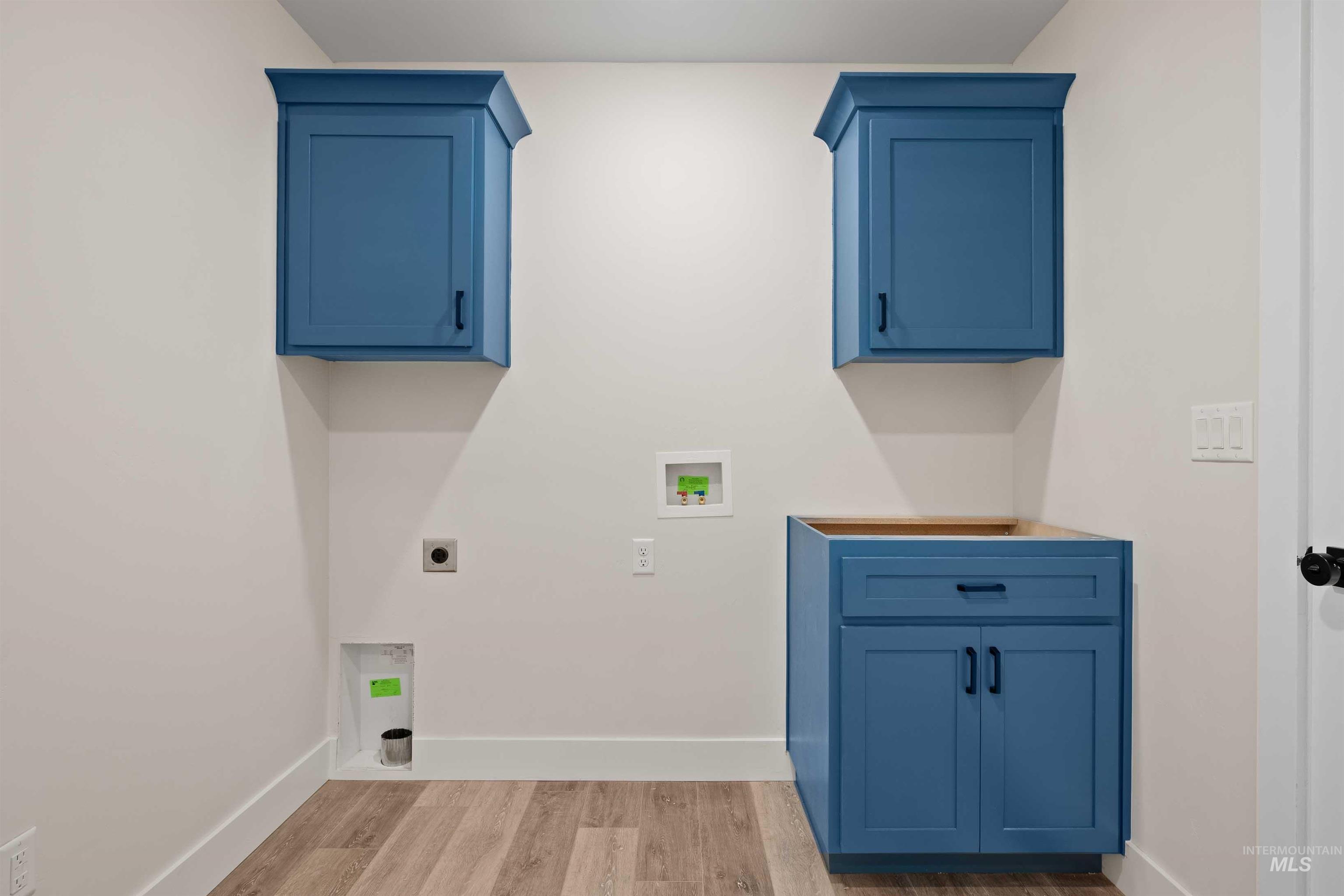 Laundry room with hookup for a washing machine, electric dryer hookup, and light wood finished floors