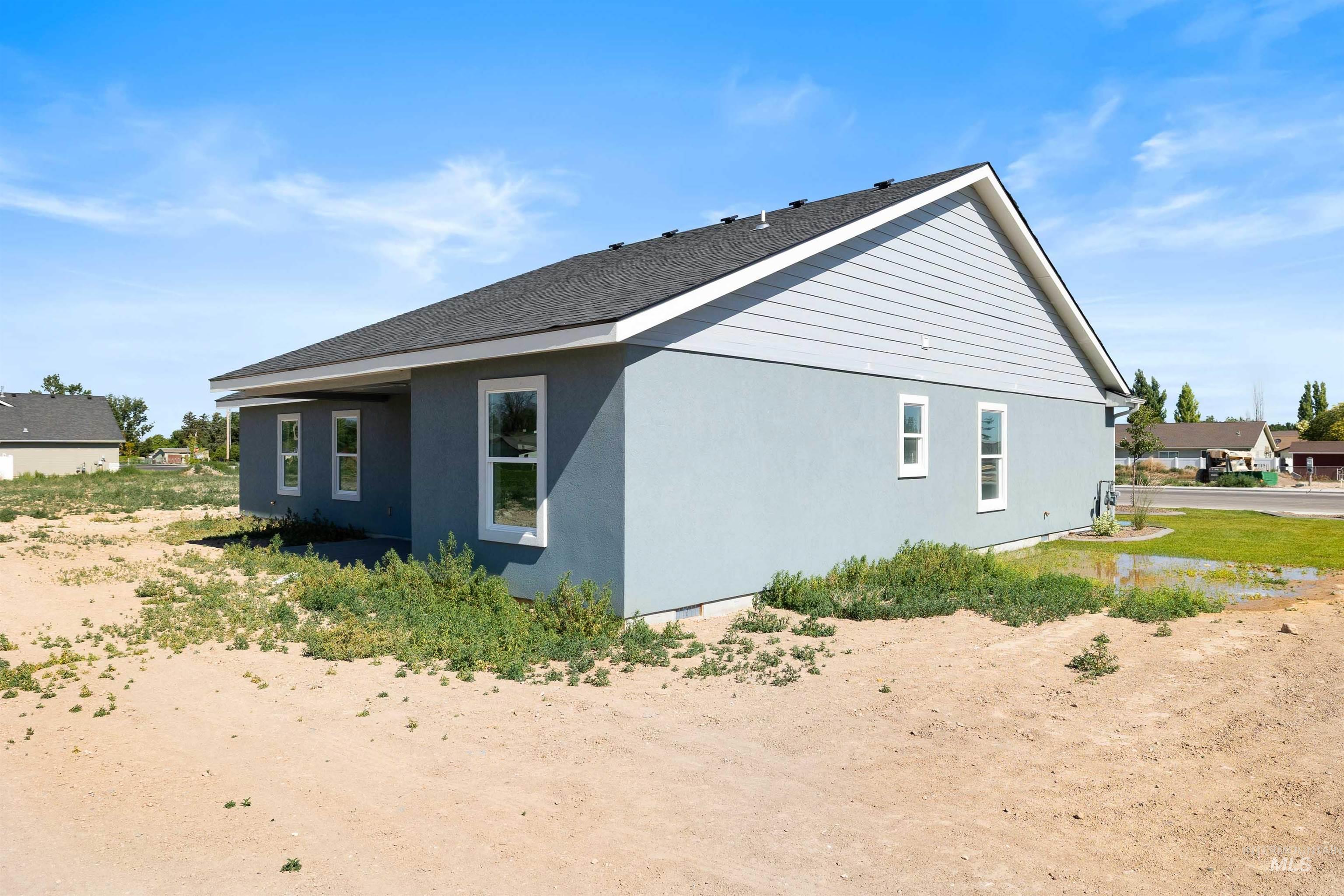 View of side of property with stucco siding and a shingled roof