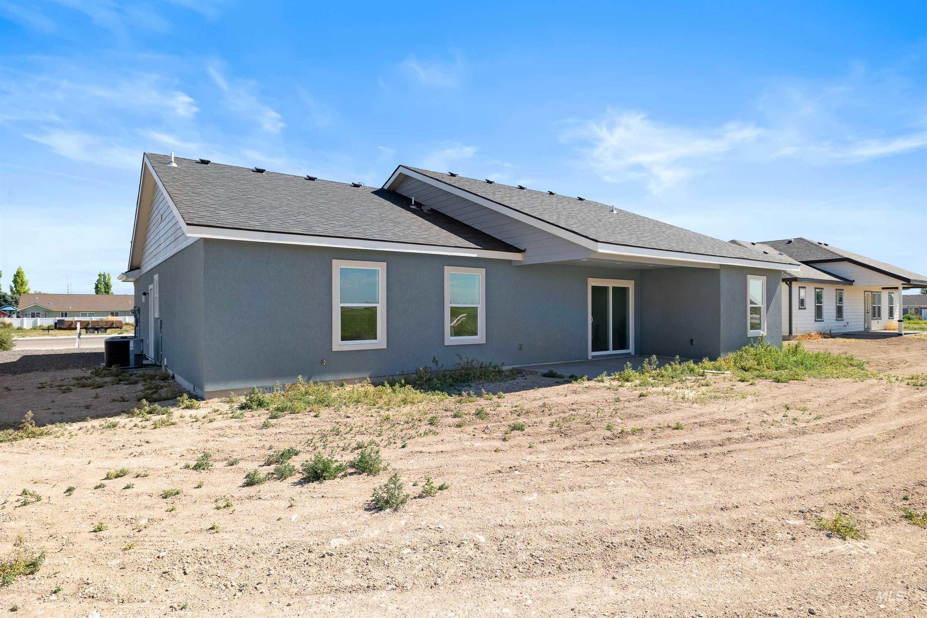 Rear view of house featuring a shingled roof and stucco siding