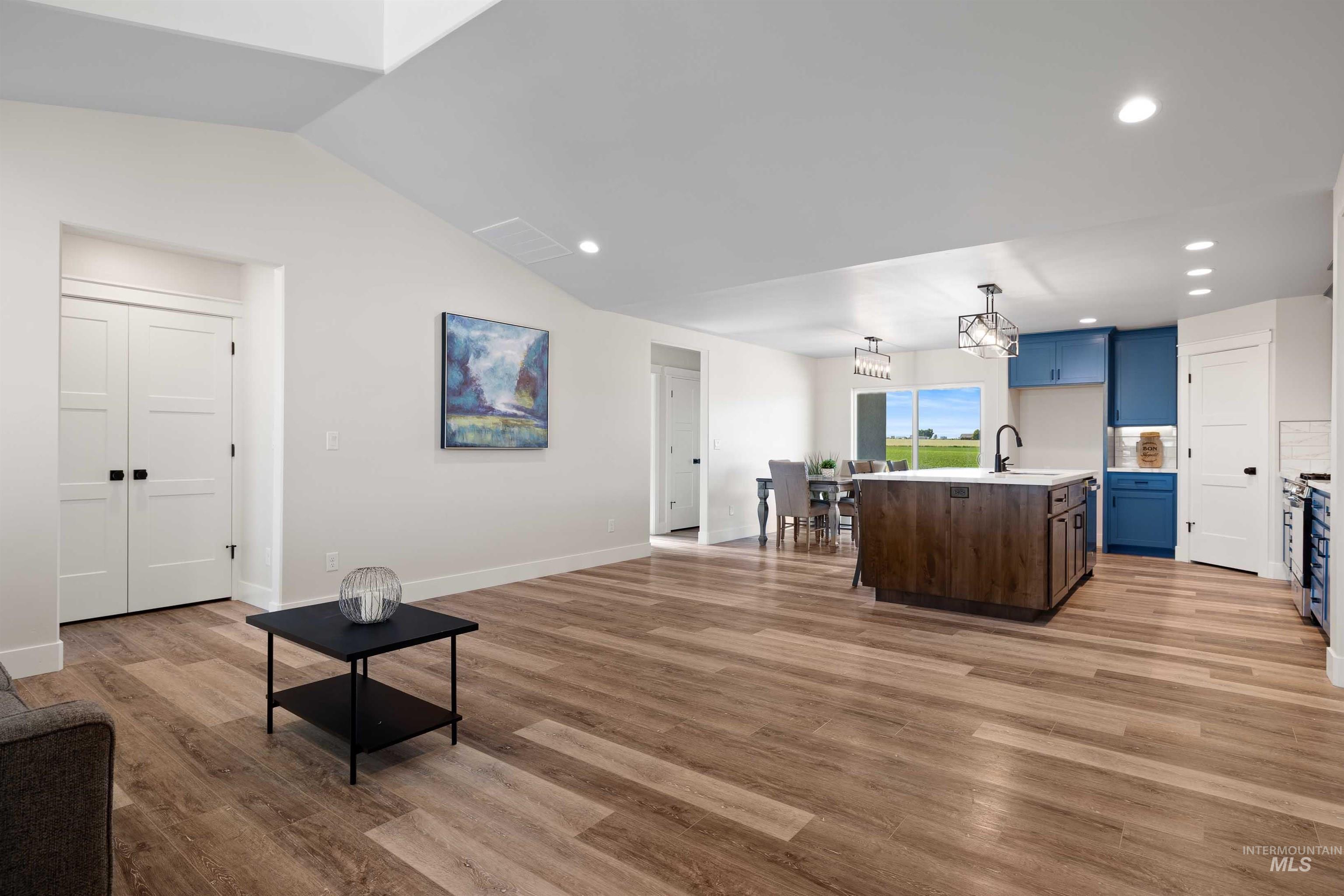 Living area with lofted ceiling, light wood-type flooring, recessed lighting, and a chandelier