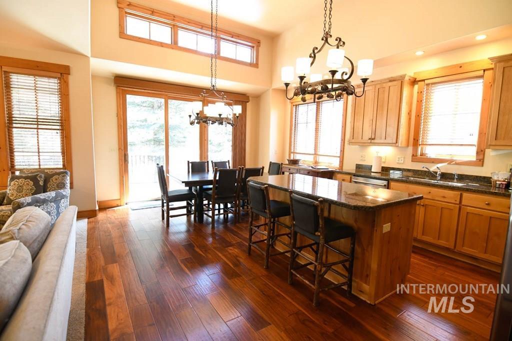 Kitchen featuring a center island, decorative light fixtures, dark stone countertops, open floor plan, and a towering ceiling